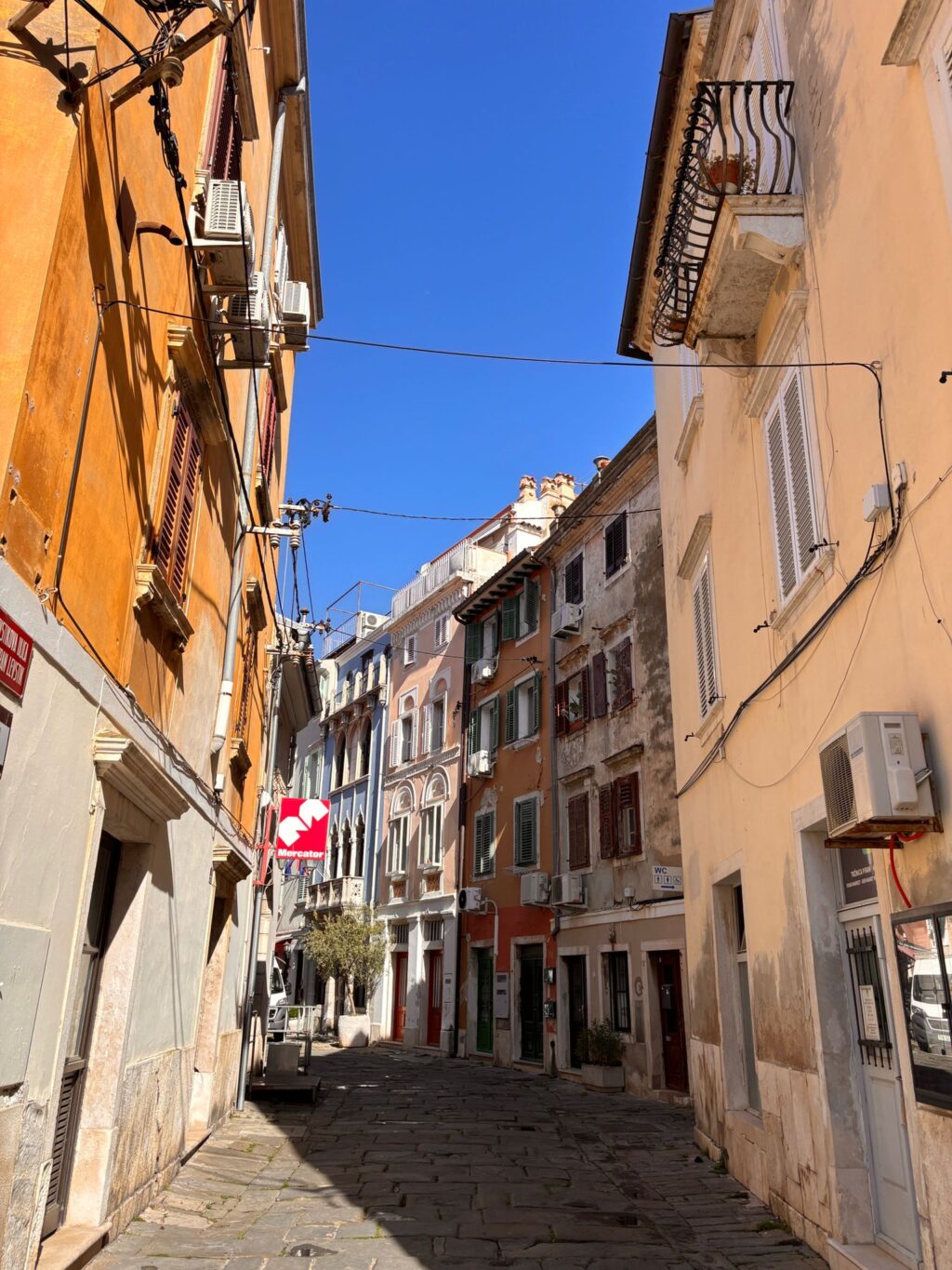 Una stradina di Piran con un supermercato Mercator